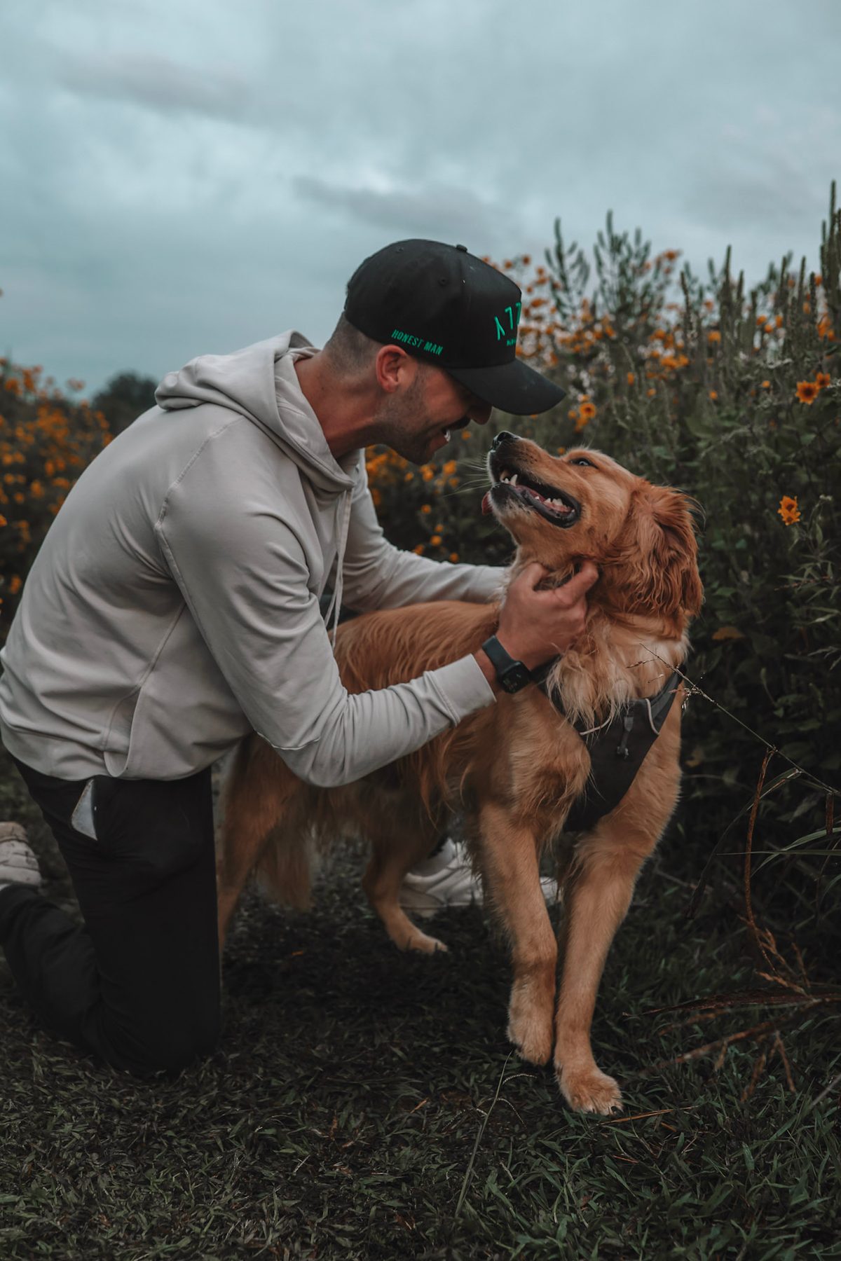 Brian Martori and Claude, his golden retriever, in a field of wildflowers